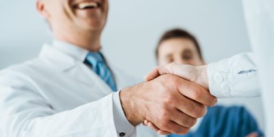 Professional doctors handshaking at hospital, hands close up, agreement and hiring concept